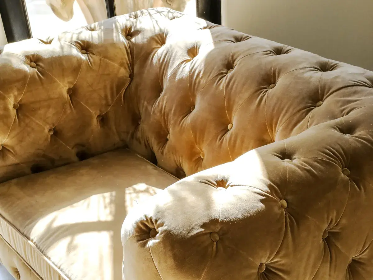 Deep buttoned custom sofa upholstered in champagne velvet for a home in Jubilee Hills, Hyderabad Deep buttoned custom sofa upholstered in champagne velvet for a home in Jubilee Hills, Hyderabad